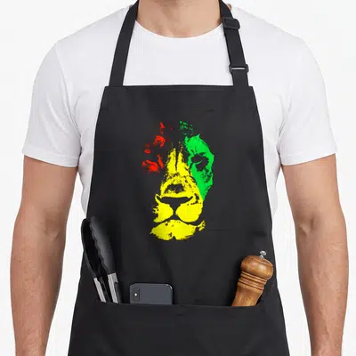 Tablier de cuisine noir avec une illustration stylisée d'un visage de lion aux couleurs vert, jaune et rouge.