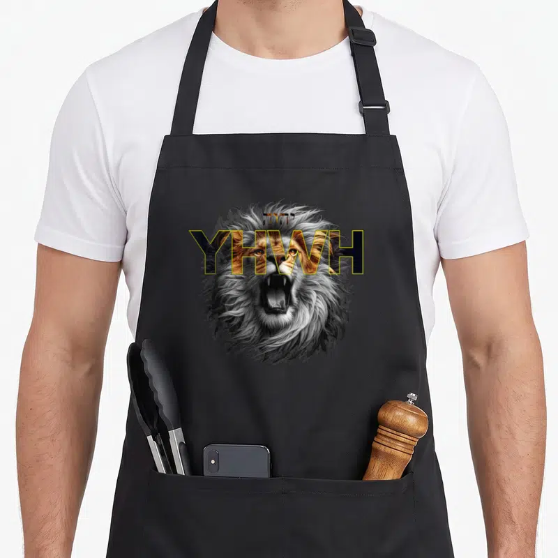 Tablier de cuisine noir avec tête de lion rugissante et inscription YHWH en lettres dorées et noires.