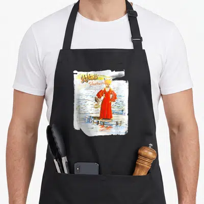 Tablier de cuisine noir avec illustration d'un renard en robe rouge tenant un poisson sur des marches d'eau.