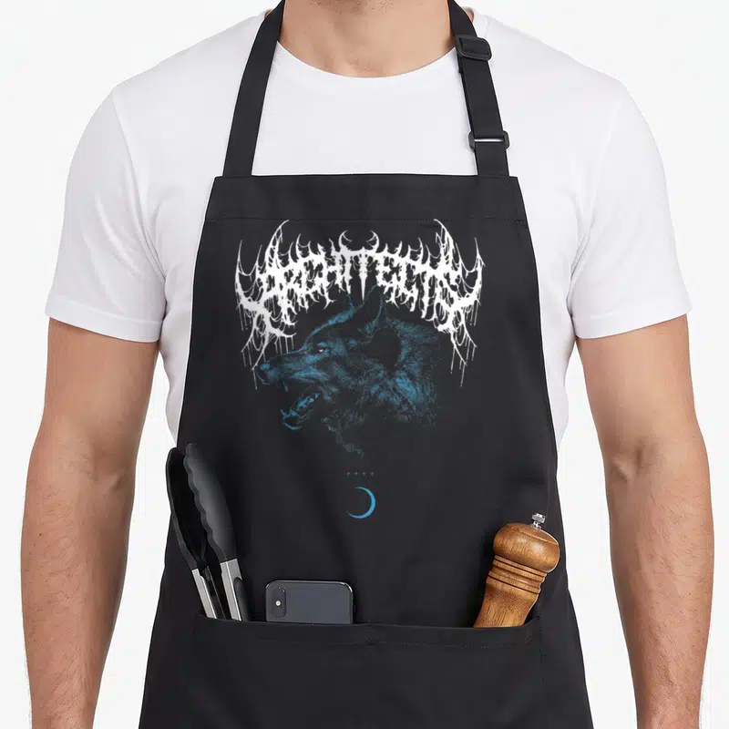 Tablier de cuisine noir avec tête de loup bleue et logo blanc dentelé sur fond gris uni