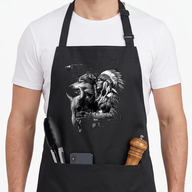 Tablier de cuisine noir avec illustration d'un Indien amérindien et d'un loup tenant un crâne animal en noir et blanc.