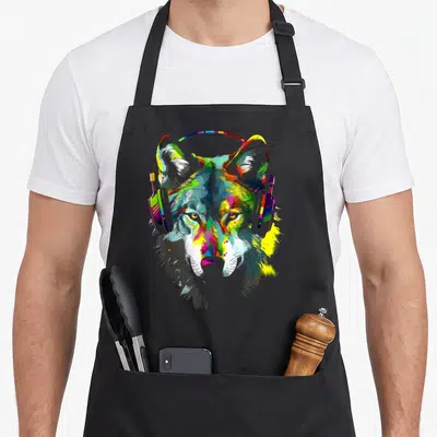 Tablier de cuisine noir avec tête de loup multicolore portant un casque audio numérique et artistique.