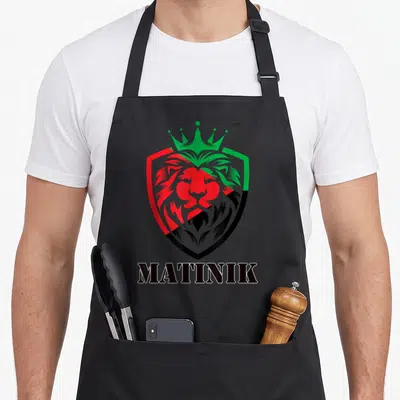 Tablier de cuisine noir avec un lion couronné aux couleurs du drapeau Martinique et le mot MATINIK en bas.