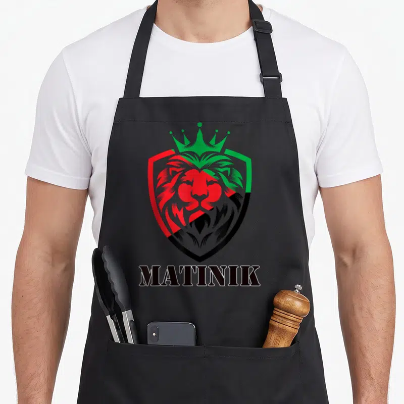 Tablier de cuisine noir avec un lion couronné aux couleurs du drapeau Martinique et le mot MATINIK en bas.