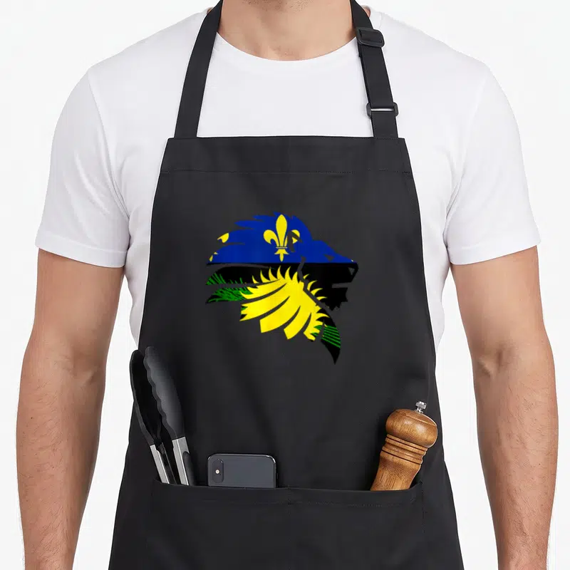 Tablier de cuisine noir avec un loup stylisé aux couleurs de la Guadeloupe et une fleur de lys dorée sur le front.
