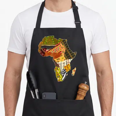 Tablier de cuisine noir avec une carte d'Afrique remplie de motifs tribaux colorés et de patterns géométriques traditionnels.