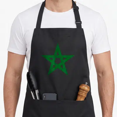 Tablier de cuisine noir avec une grande étoile verte à cinq branches imprimée au centre du vêtement.