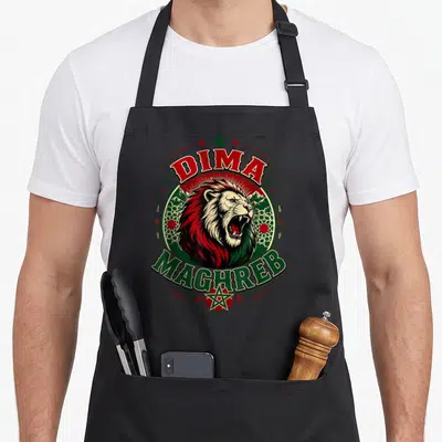 Tablier de cuisine noir avec un lion rugissant, les mots Dima Maghreb et des motifs géométriques verts et rouges.