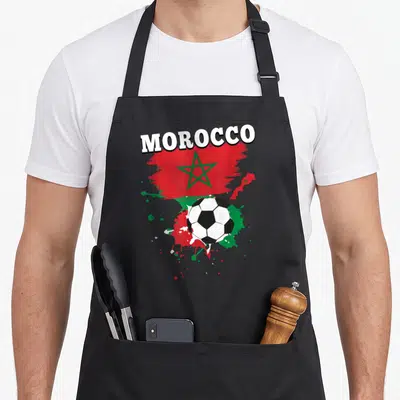 Tablier de cuisine noir avec illustration Morocco drapeau et ballon de football aux couleurs nationales.