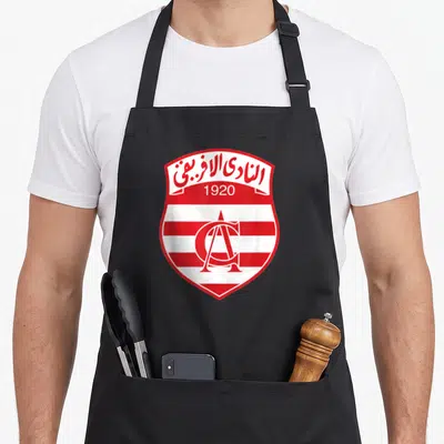 Tablier de cuisine noir avec l'écusson rouge et blanc du Club Africain et l'année 1920 imprimés au centre.