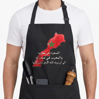 Tablier de cuisine noir avec carte du Maroc rouge, étoile verte et texte patriotique en calligraphie arabe blanche.