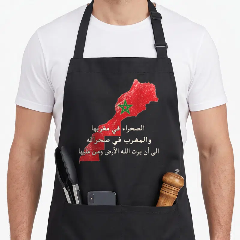 Tablier de cuisine noir avec carte du Maroc rouge, étoile verte et texte patriotique en calligraphie arabe blanche.