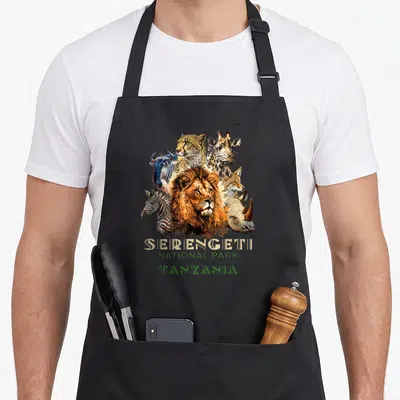 Tablier de cuisine noir avec illustration de lions, girafes et zèbres du parc national du Serengeti en Tanzanie.