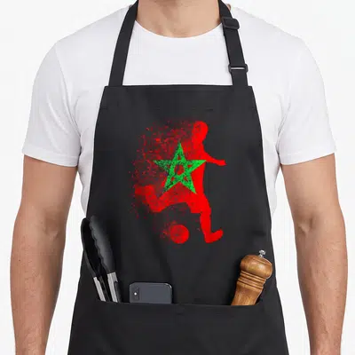 Tablier de cuisine noir avec silhouette rouge de footballeur et étoile verte style éclaboussure.