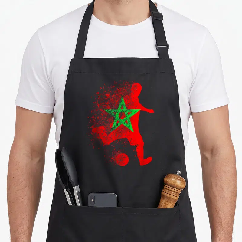 Tablier de cuisine noir avec silhouette rouge de footballeur et étoile verte style éclaboussure.