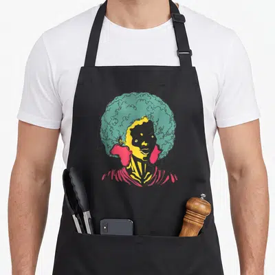 Tablier de cuisine noir avec portrait femme afro aux cheveux verts et boucles d'oreilles roses vives.
