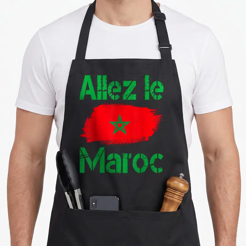 Tablier de cuisine noir avec une touche de peinture rouge portant une étoile verte et le message Allez le Maroc en lettres vertes.