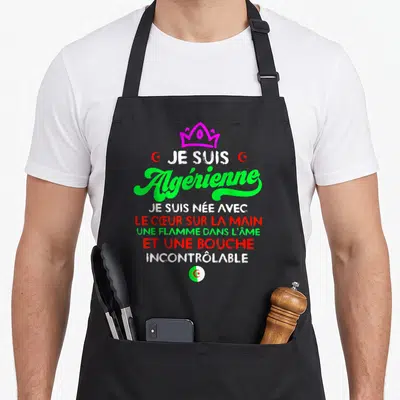 Tablier de cuisine noir avec inscription Je suis Algérienne et une couronne rose vif sur fond uni.