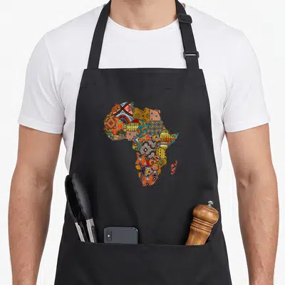 Tablier de cuisine noir avec carte d'Afrique composée de tissus et motifs ethniques multicolores.