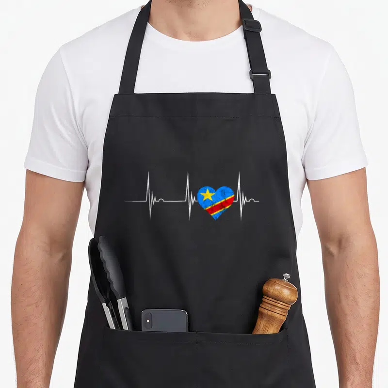 Tablier de cuisine noir avec un cœur aux couleurs du Congo intégré dans une ligne blanche d'ECG sur fond uni.