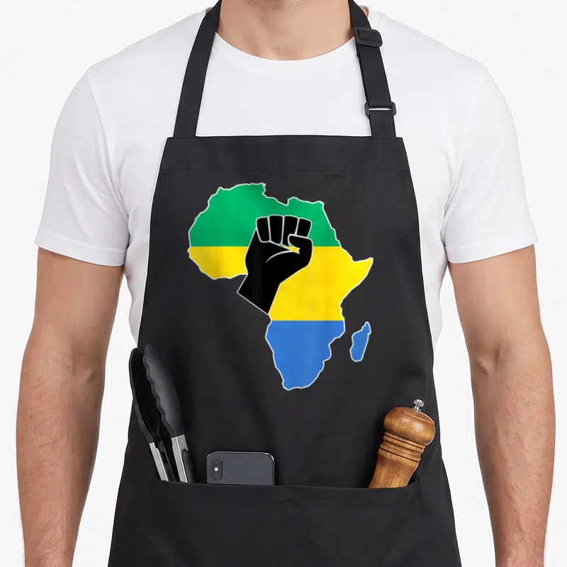Tablier de cuisine noir avec carte Afrique drapeau vert jaune bleu et poing levé noir central.