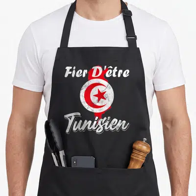 Tablier de cuisine noir avec une carte de Tunisie rouge et le texte Fier d'être Tunisien en blanc vieilli.