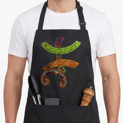 Tablier de cuisine noir avec le symbole Tifinagh Amazigh YAZ coloré et des motifs géométriques berbères traditionnels.