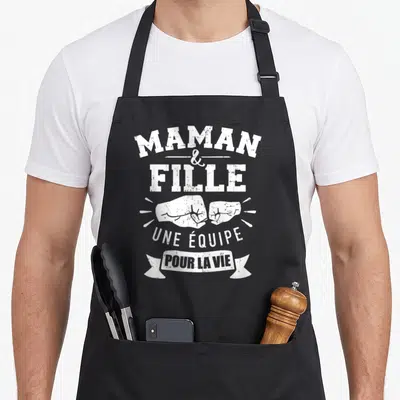 Tablier de cuisine noir avec inscription Maman et Fille Une équipe pour la vie et deux poings se touchant en blanc.