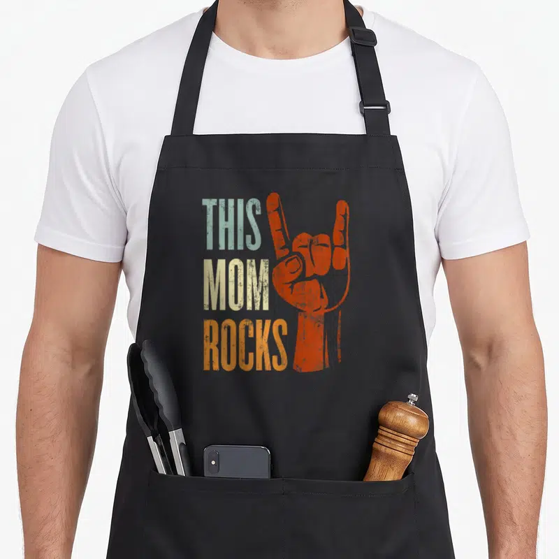 Tablier de cuisine noir avec main en signe rock orange et texteThis Mom Rocks dégradé.