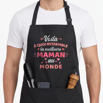 Tablier de cuisine noir avec inscription rose et blanche célébrant la meilleure maman au monde entourée de petits cœurs.