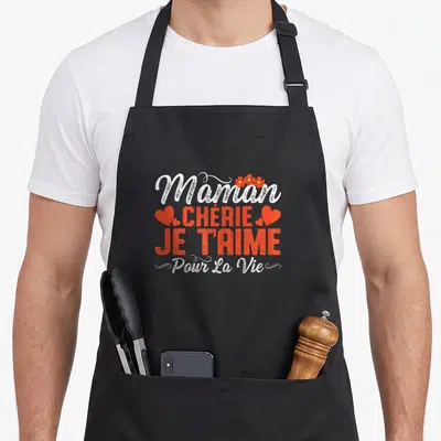 Tablier de cuisine noir avec inscription Maman Chérie Je T'Aime Pour La Vie en rouge et blanc, agrémenté de cœurs et de fleurs.