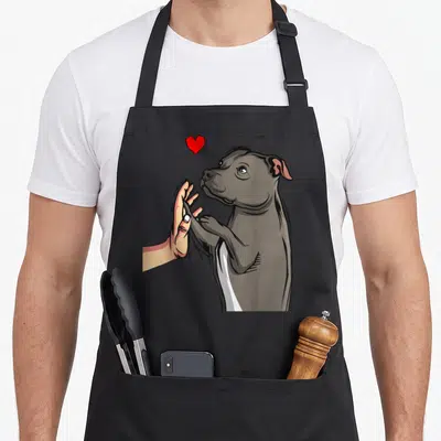 Tablier de cuisine noir avec illustration d'un chien gris et d'une main effectuant un high five sous un cœur rouge.