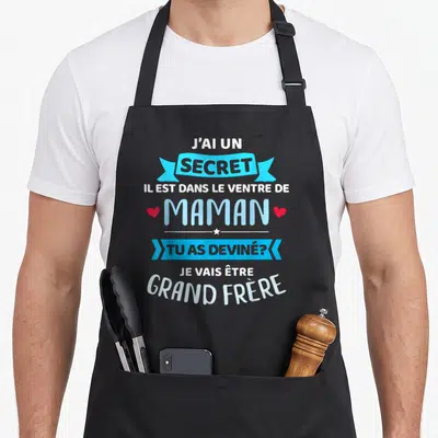 Tablier de cuisine noir avec message typographique bleu et blanc annonçant la venue d'un grand frère.