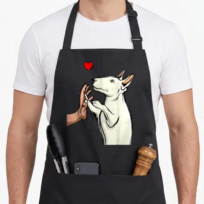 Tablier de cuisine noir avec illustration d'un Bull Terrier blanc et d'une main humaine sous un cœur rouge.
