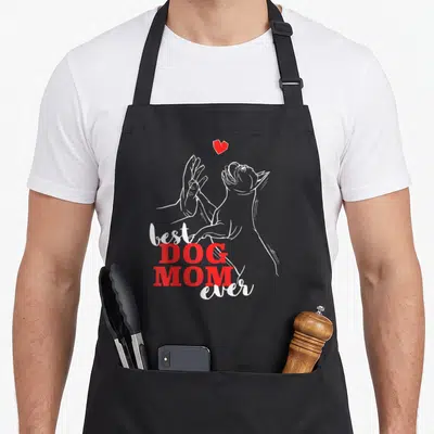Tablier de cuisine noir avec illustration blanche d'un chien et texte rouge best DOG MOM ever sous un cœur.