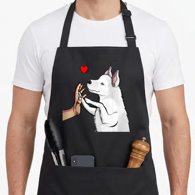 Tablier de cuisine noir avec illustration d'un husky blanc tendant une patte à une main humaine sous un petit cœur rouge vif.