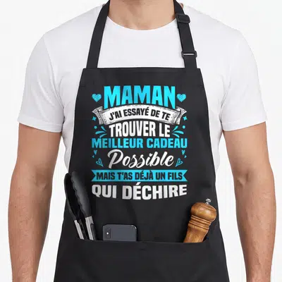 Tablier de cuisine noir avec inscription bleue et blanche Maman j'ai essayé de te trouver le meilleur cadeau possible mais t'as déjà un fils qui déchire orné de petits cœurs.