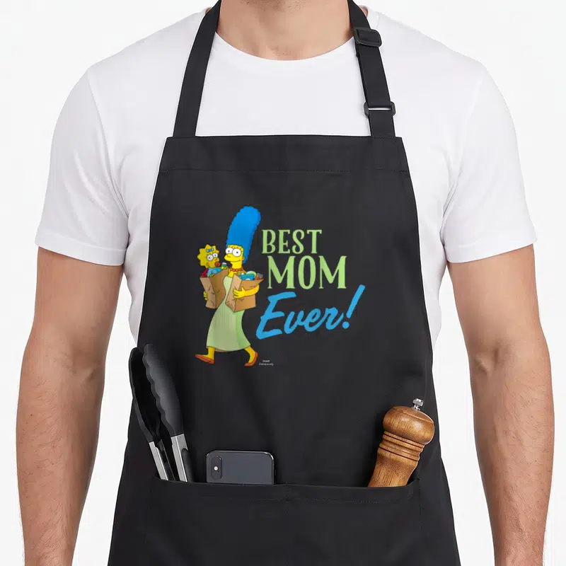 Tablier de cuisine noir avec Marge Simpson portant Maggie et des sacs en papier kraft.