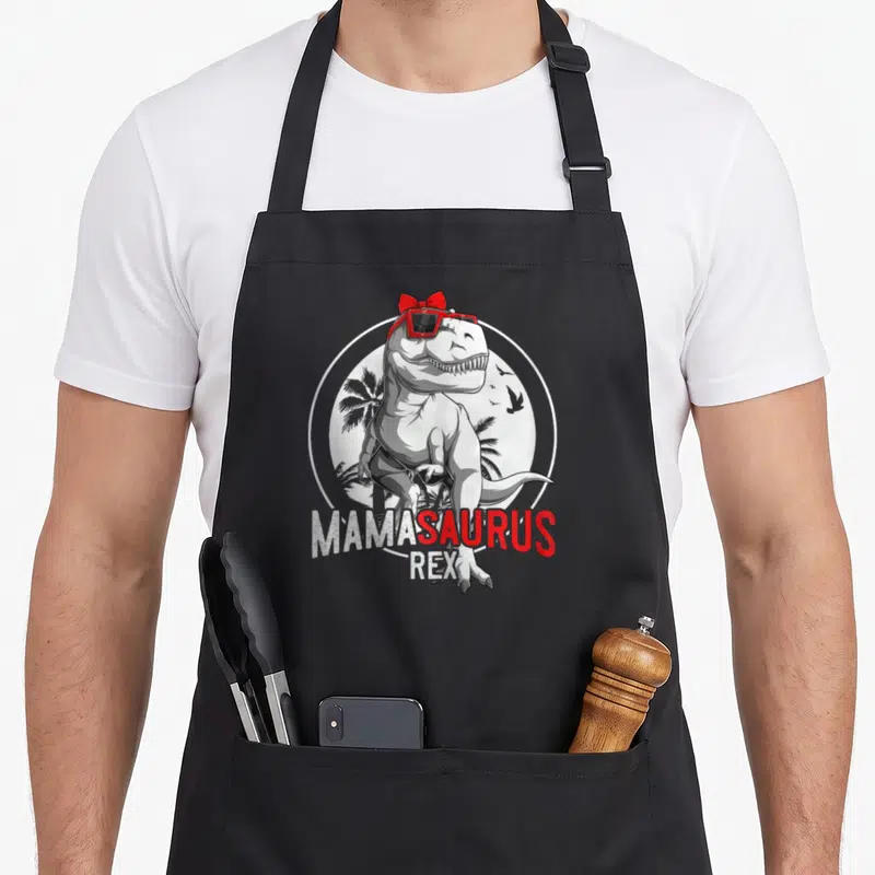 Tablier de cuisine noir avec illustration Mamasaurus Rex toupie rouge et lunettes solaires.