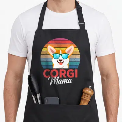 Tablier de cuisine noir avec un corgi portant des lunettes bleues sur fond arc-en-ciel et le texte Corgi Mama.