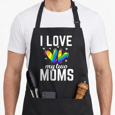 Tablier de cuisine noir avec deux cœurs arc-en-ciel et le texte blanc I Love My Two Moms.