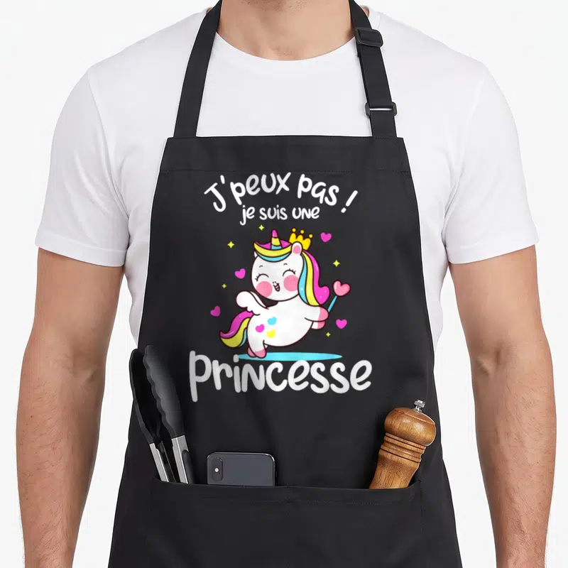 Tablier de cuisine noir avec une licorne rose et la mention J'peux pas je suis une princesse