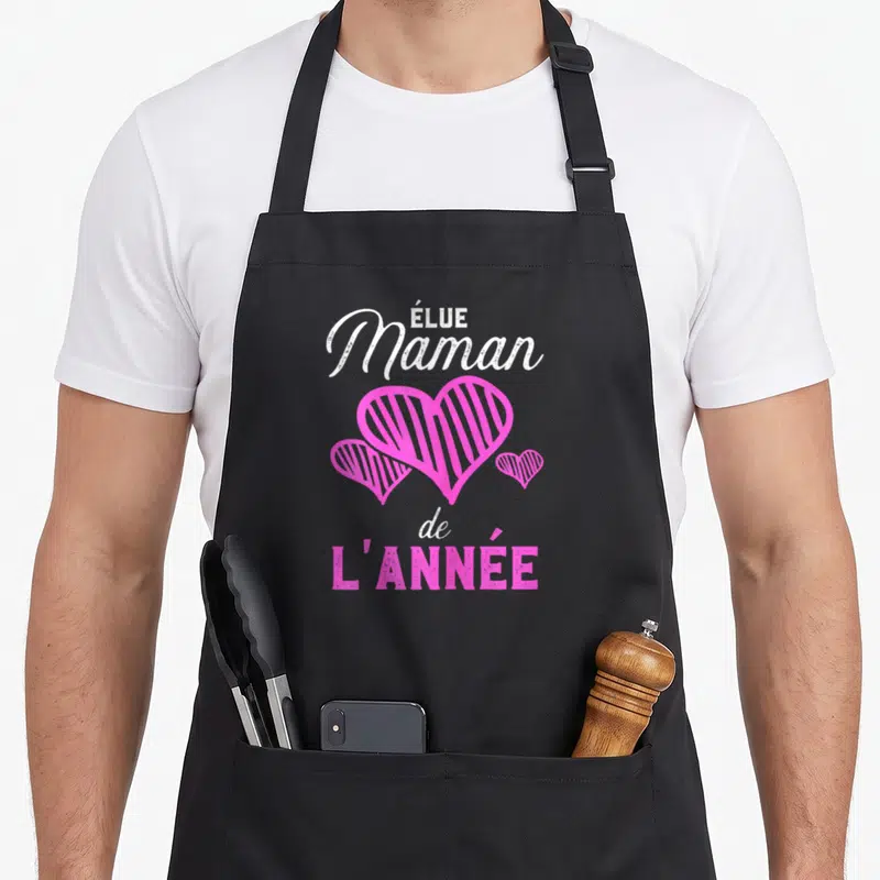 Tablier de cuisine noir avec inscription Élue Maman de l'année et trois cœurs roses striés au centre.