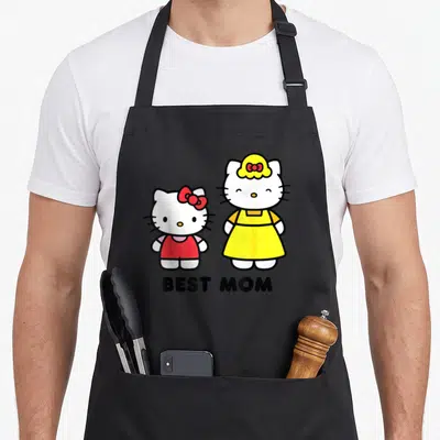 Tablier de cuisine noir avec deux personnages Hello Kitty, l'un en robe rouge et l'autre en tablier jaune, surplombés du texte Best Mom.