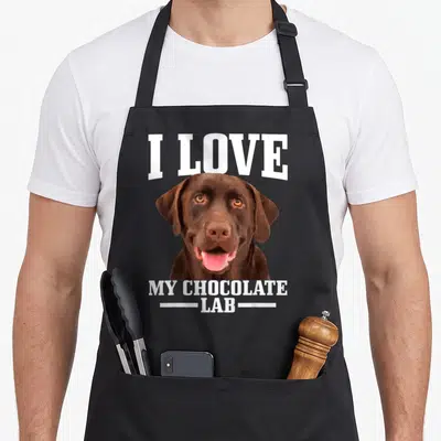 Tablier de cuisine noir avec portrait d'un chien Labrador Retriever chocolat et texte blanc en anglais.