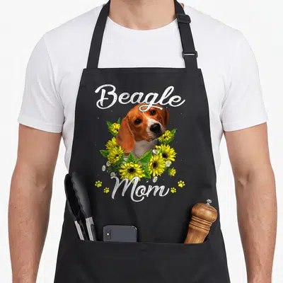 Tablier de cuisine noir avec illustration d'un beagle entouré de fleurs de tournesol et du texte Beagle Mom en blanc.