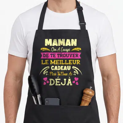 Tablier de cuisine noir avec inscription jaune et rose « Maman on a essayé de te trouver le meilleur cadeau mais tu nous a déjà » entouré de cœurs roses.
