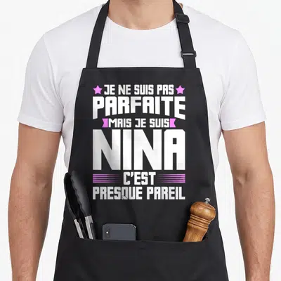 Tablier de cuisine noir avec le texte blanc et rose Je ne suis pas parfaite mais je suis Nina c'est presque pareil.