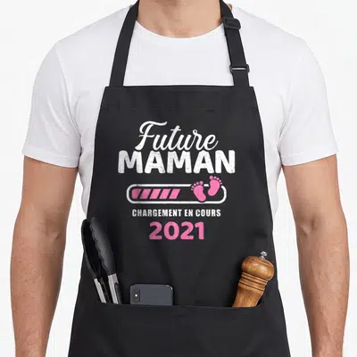 Tablier de cuisine noir avec inscription Future Maman chargement en cours 2021 et icône de pieds roses.