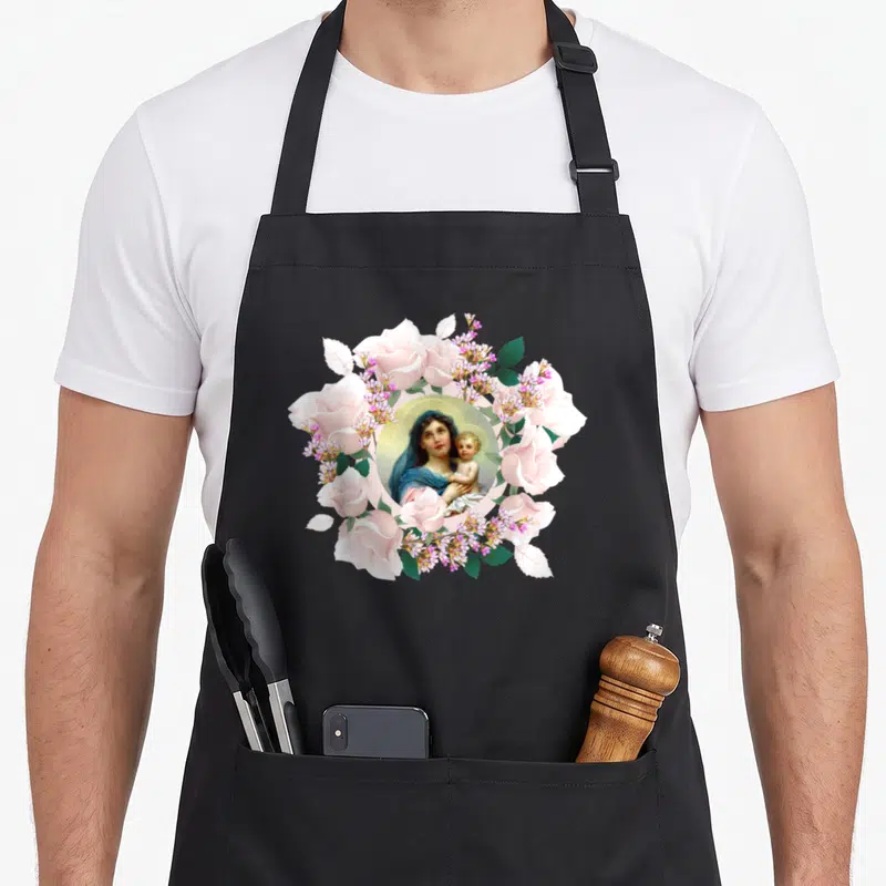 Tablier de cuisine noir avec une illustration circulaire de Marie et Jésus entourés de roses roses et de fleurs violettes sur fond uni.